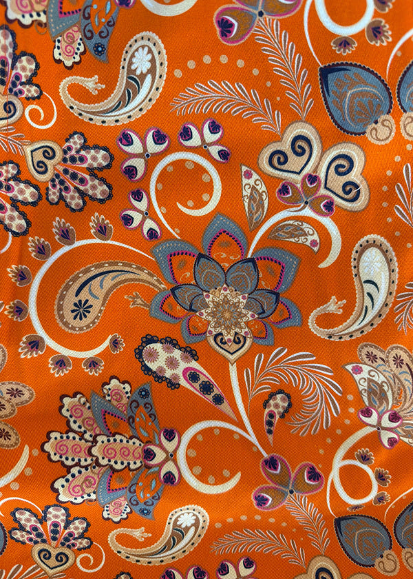 Orangish fabric with intricate paisley and floral patterns