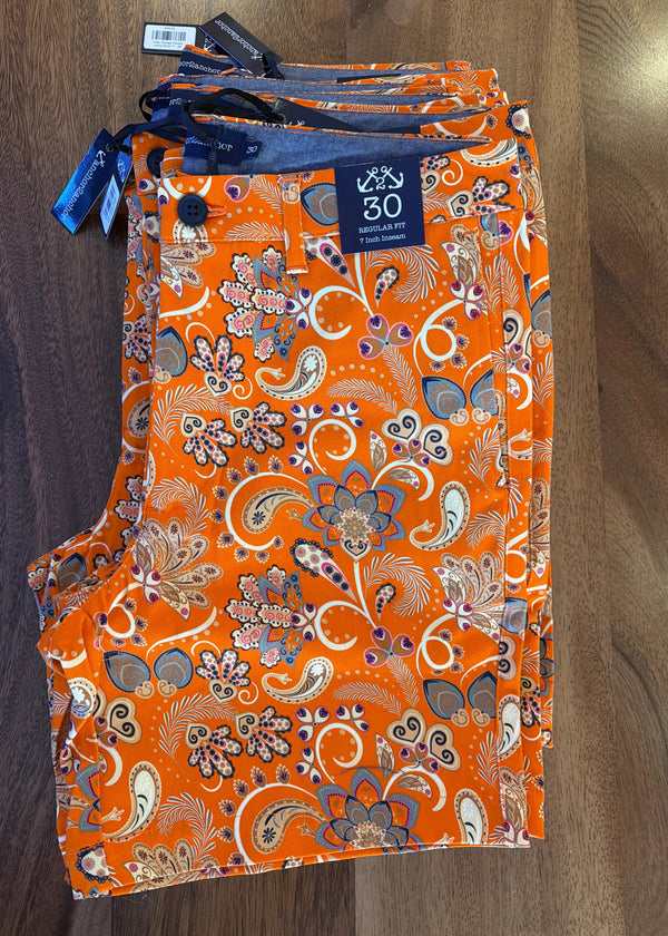 Orange patterned fabric with a tag on a wooden surface