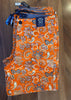 Orange patterned fabric with a tag on a wooden surface