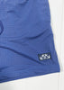 Blue shorts with a logo patch on a white background
