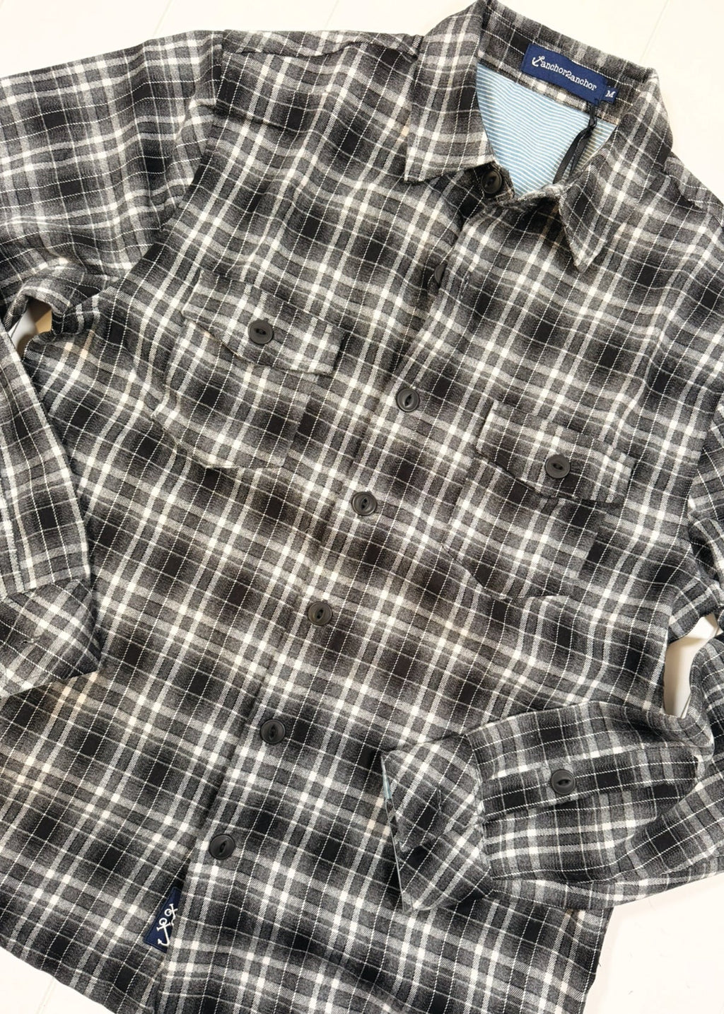 Plaid shirt with a brand label on a white background