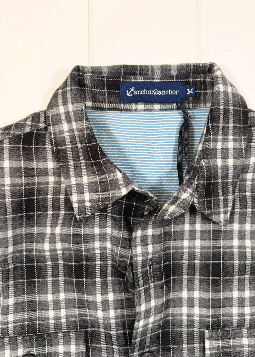 Plaid shirt with a visible brand label on a light background