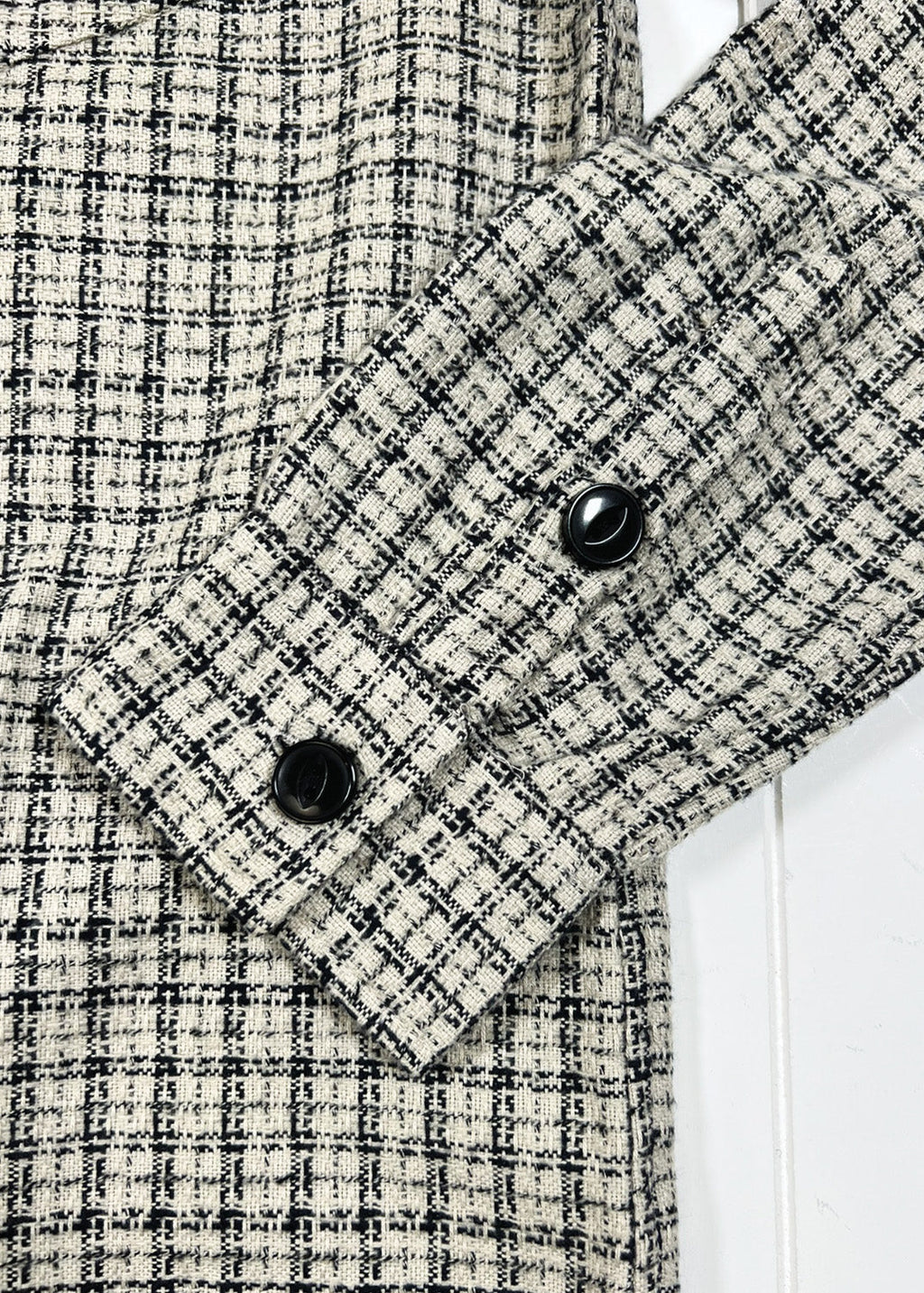 Close-up of a checkered shirt with buttons on a white background