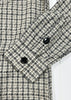Close-up of a checkered shirt with buttons on a white background