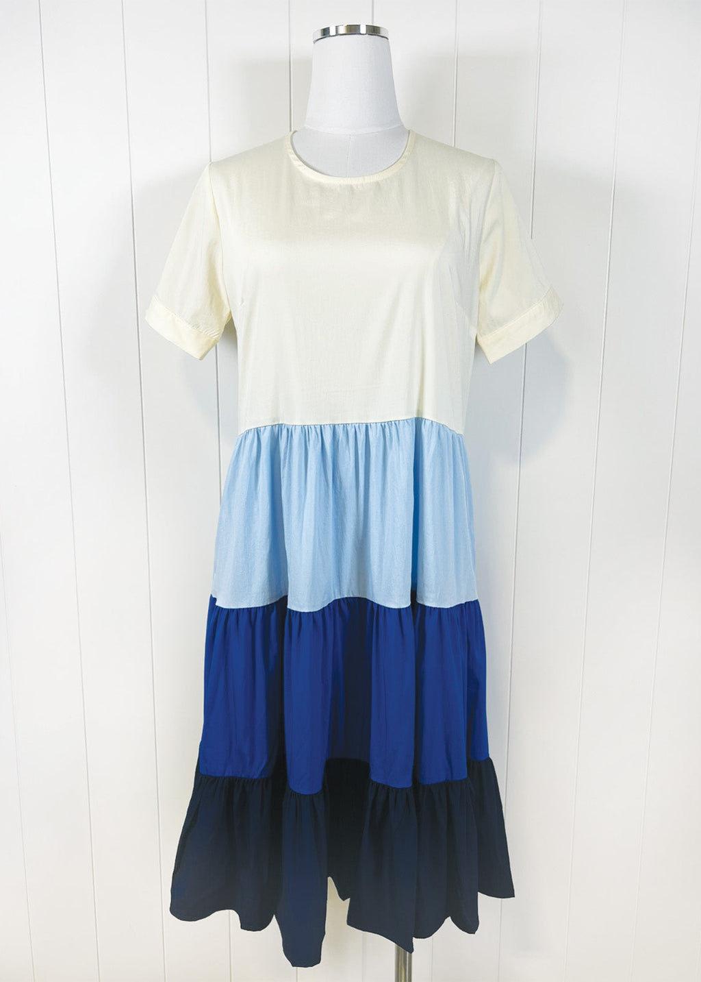 Color-blocked dress with cream, blue, and navy on a mannequin against a white background