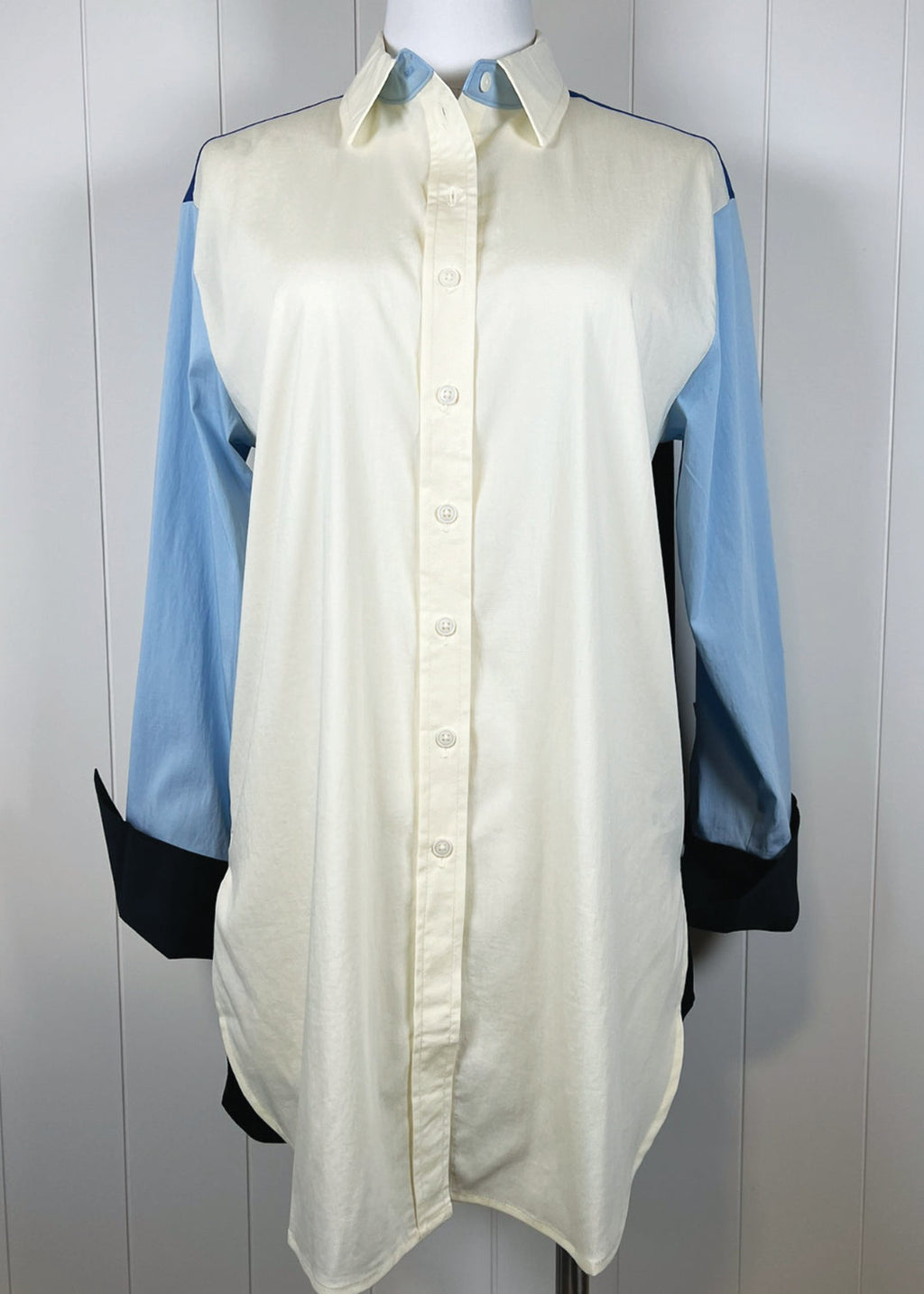 Light green shirt with blue sleeves on a mannequin against a white background