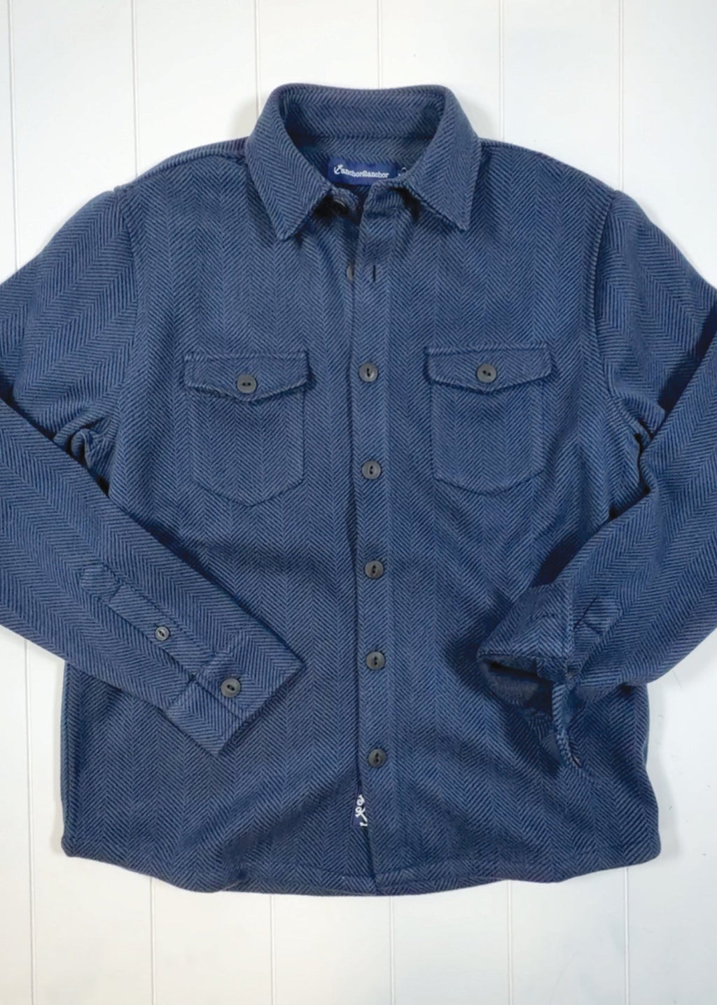 Blue shirt with collar and two front pockets on a white background