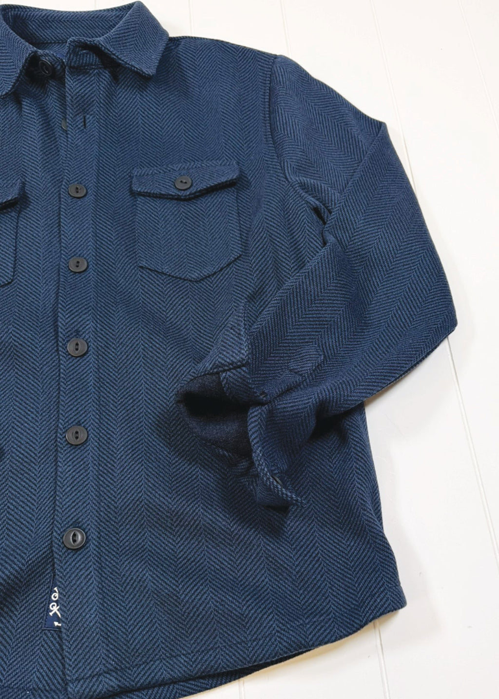 Blue textured shirt with buttons on a white background