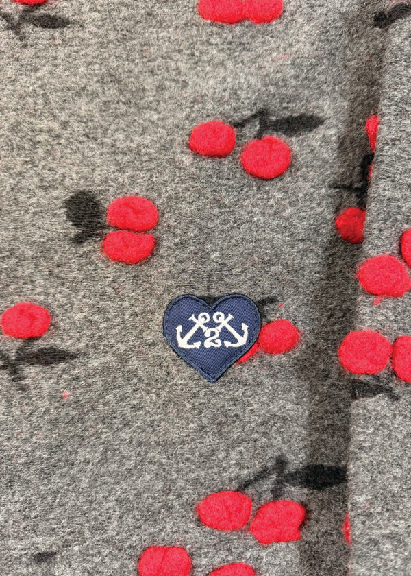 Gray fabric with red floral patterns and a blue heart patch with an anchor design.