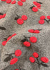 Close-up of a fabric with red cherry patterns on a gray background