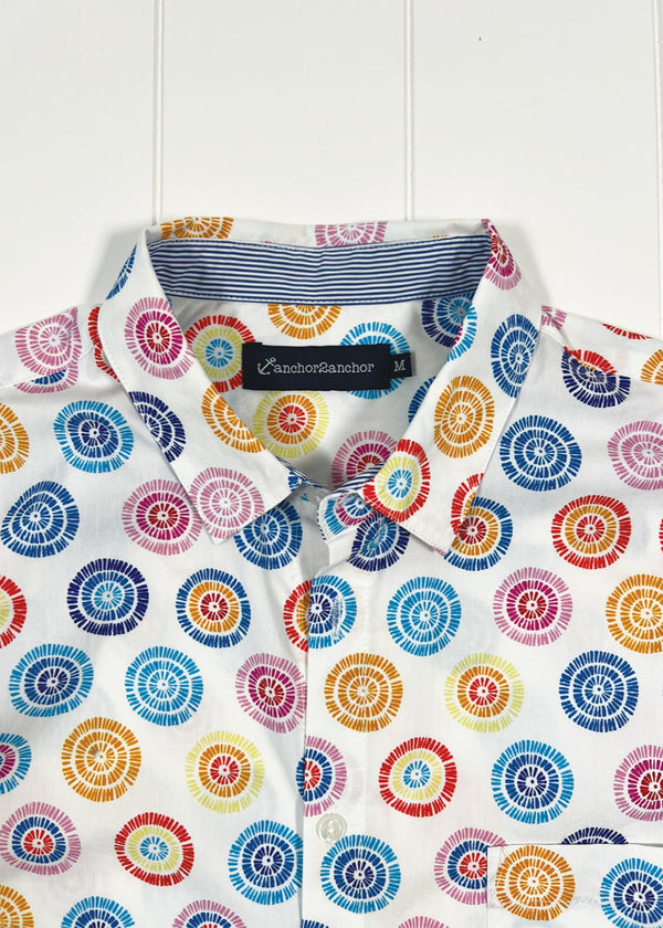 Colorful circular patterned shirt with a brand label on a white background
