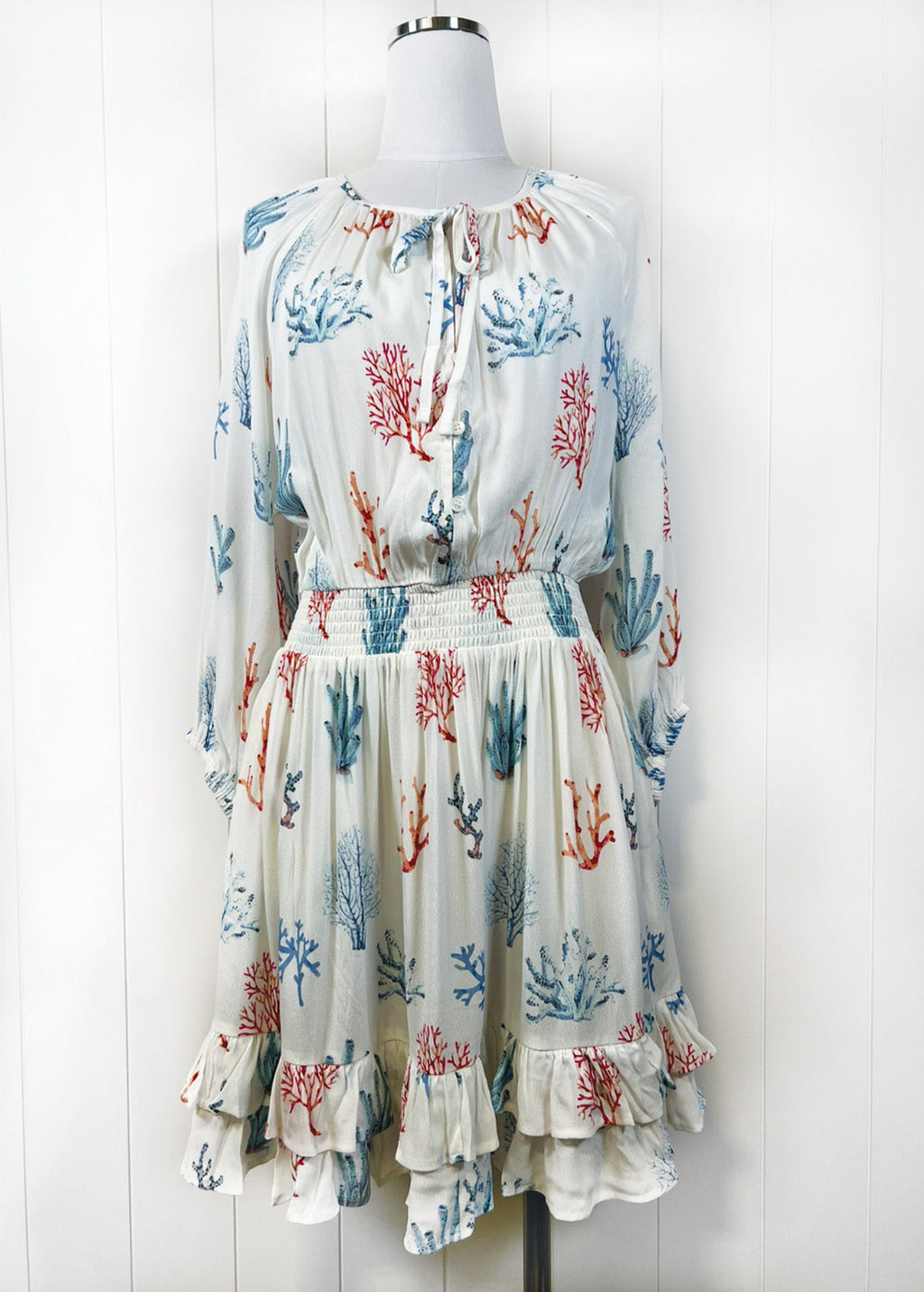 Dress with coral pattern on a mannequin against a white background