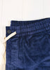 Close-up of blue corduroy shorts with a button on a white background