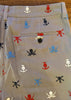 Beige shirt with colorful skull and anchor patterns on a wooden surface