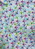 Patterned fabric with star shapes in purple, green, and blue on a light blue background