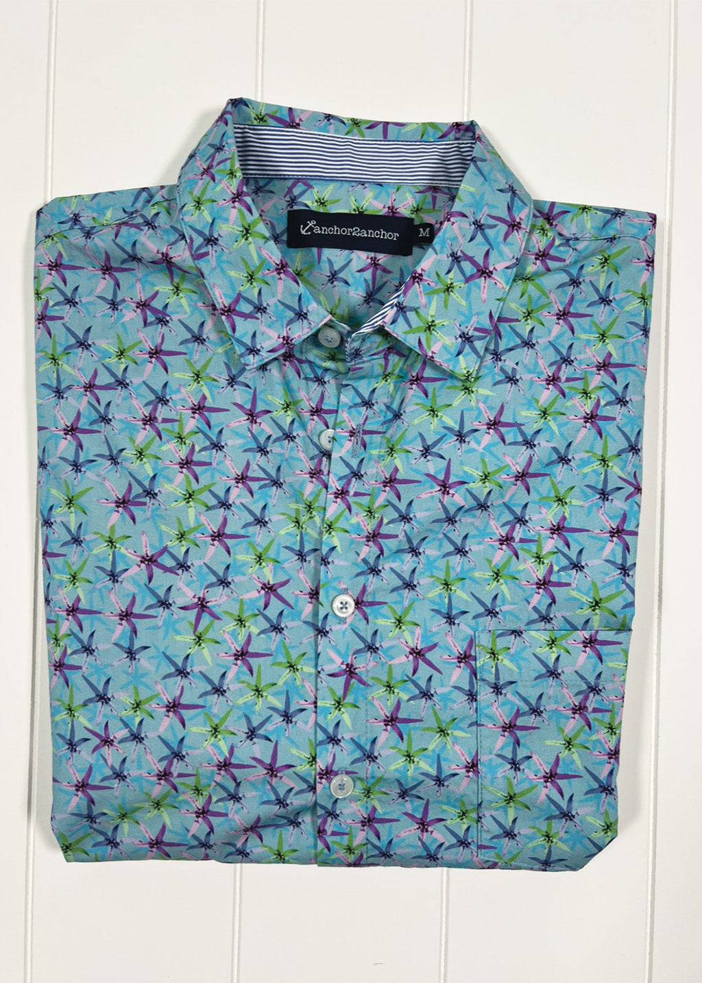 Folded shirt with colorful geometric pattern on a white background