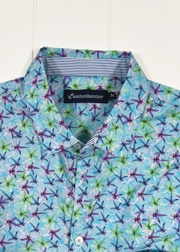 Colorful patterned shirt with a brand label on a white background