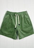 Green shorts with a drawstring on a white wooden background