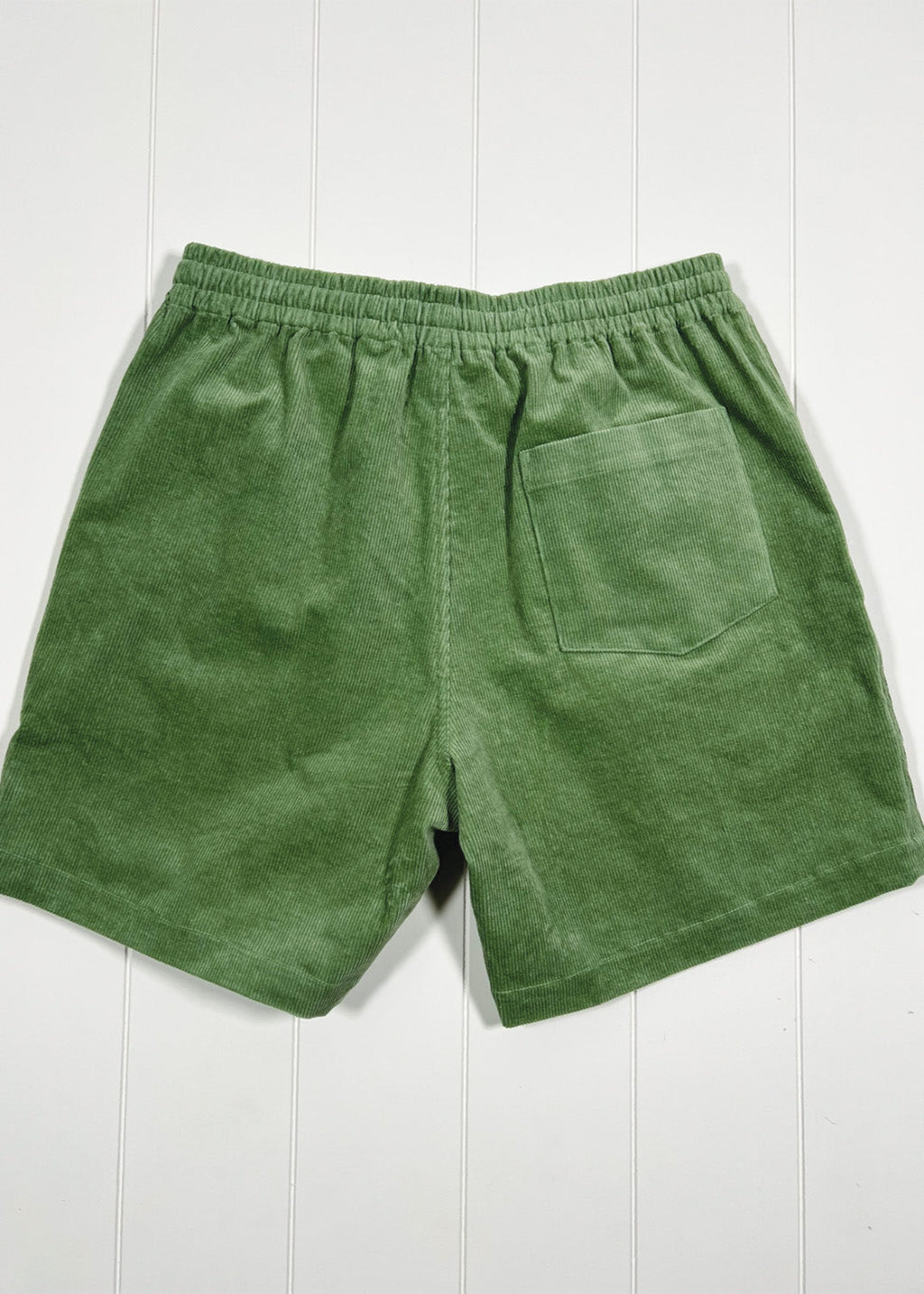 Green shorts on a white wooden background