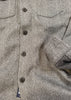 Close-up of a textured fabric with buttons on a herringbone pattern