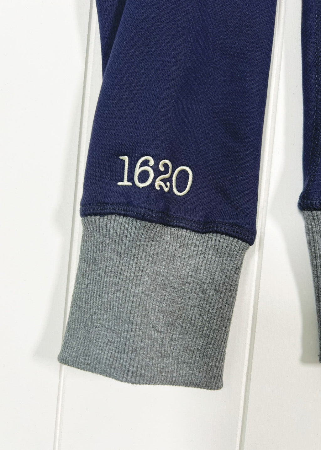 Navy blue sweatshirt with gray cuffs and '1620' embroidery on a white background