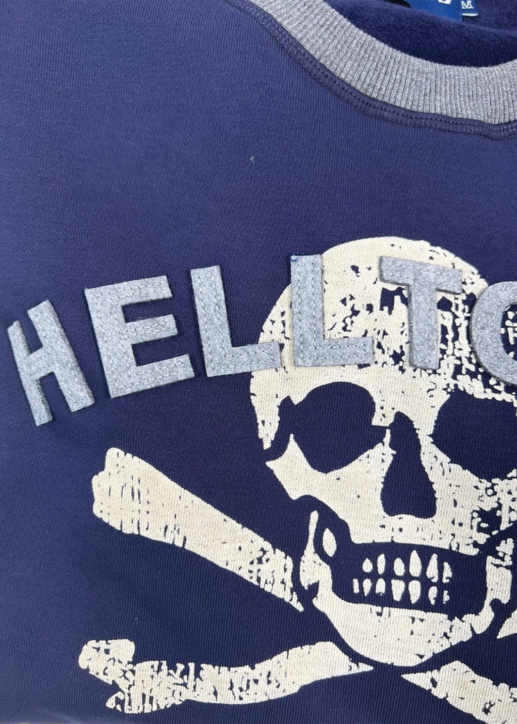 Navy blue sweatshirt with skull and crossbones design and 'HELLT' text.