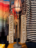 A close-up of beaded keychains with 'PROVINCETOWN' text hanging from a display stand in a retail setting. The keychains feature cream and tan beading with gold-toned lettering, alongside a black tag from AuditorFashion.