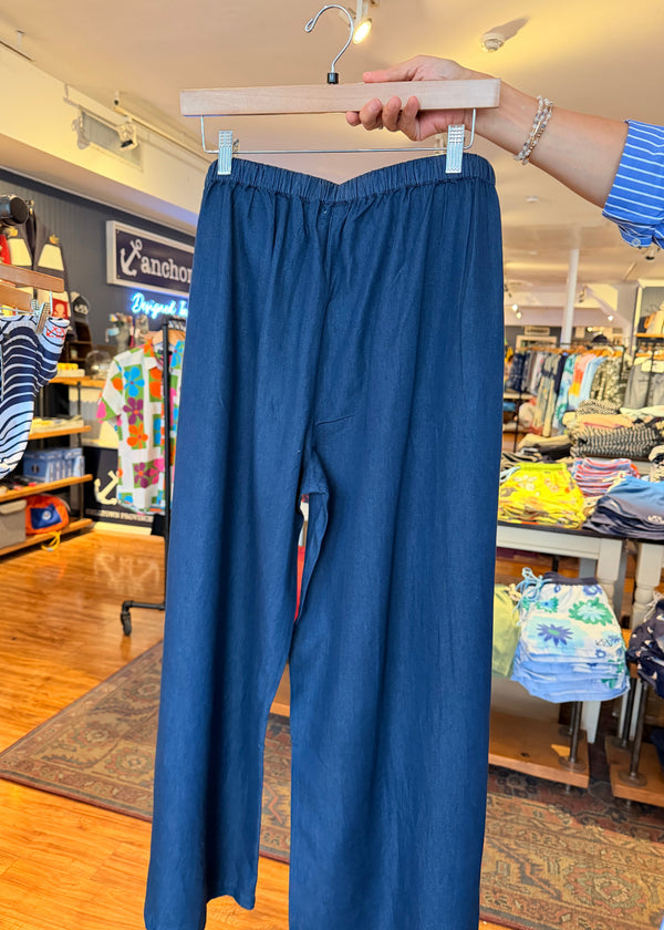 Person holding a blue dress up against a store window display.