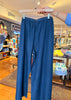 Person holding a blue dress up against a store window display.