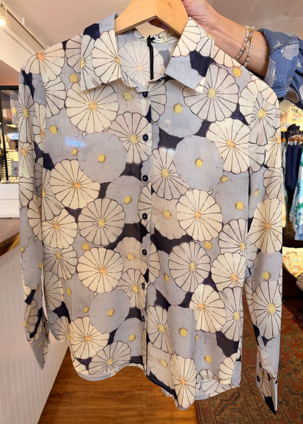 Floral-patterned fabric held by a person with a blurred indoor background