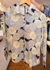 Floral-patterned fabric held by a person with a blurred indoor background