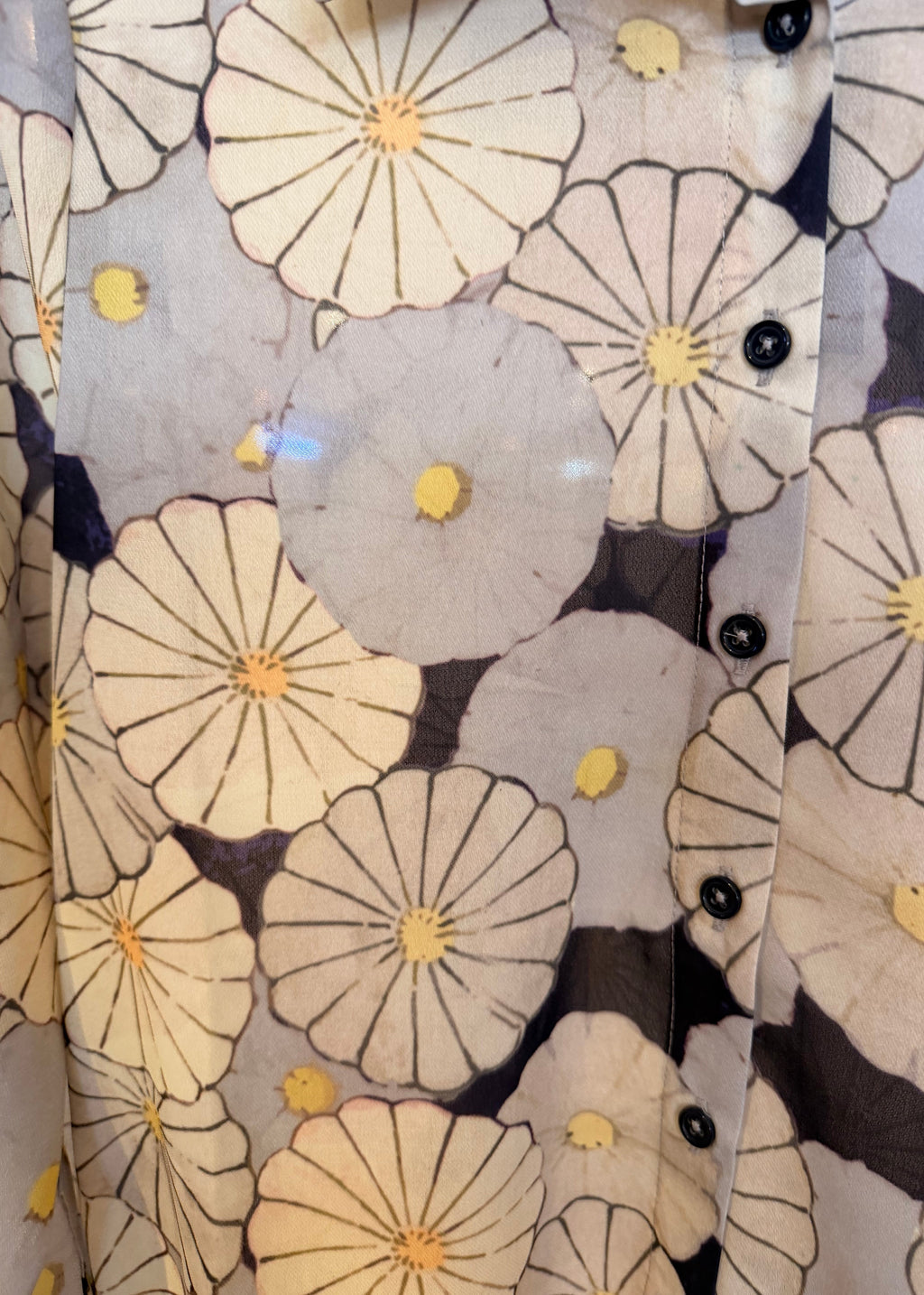 Close-up of a floral patterned fabric with black buttons.