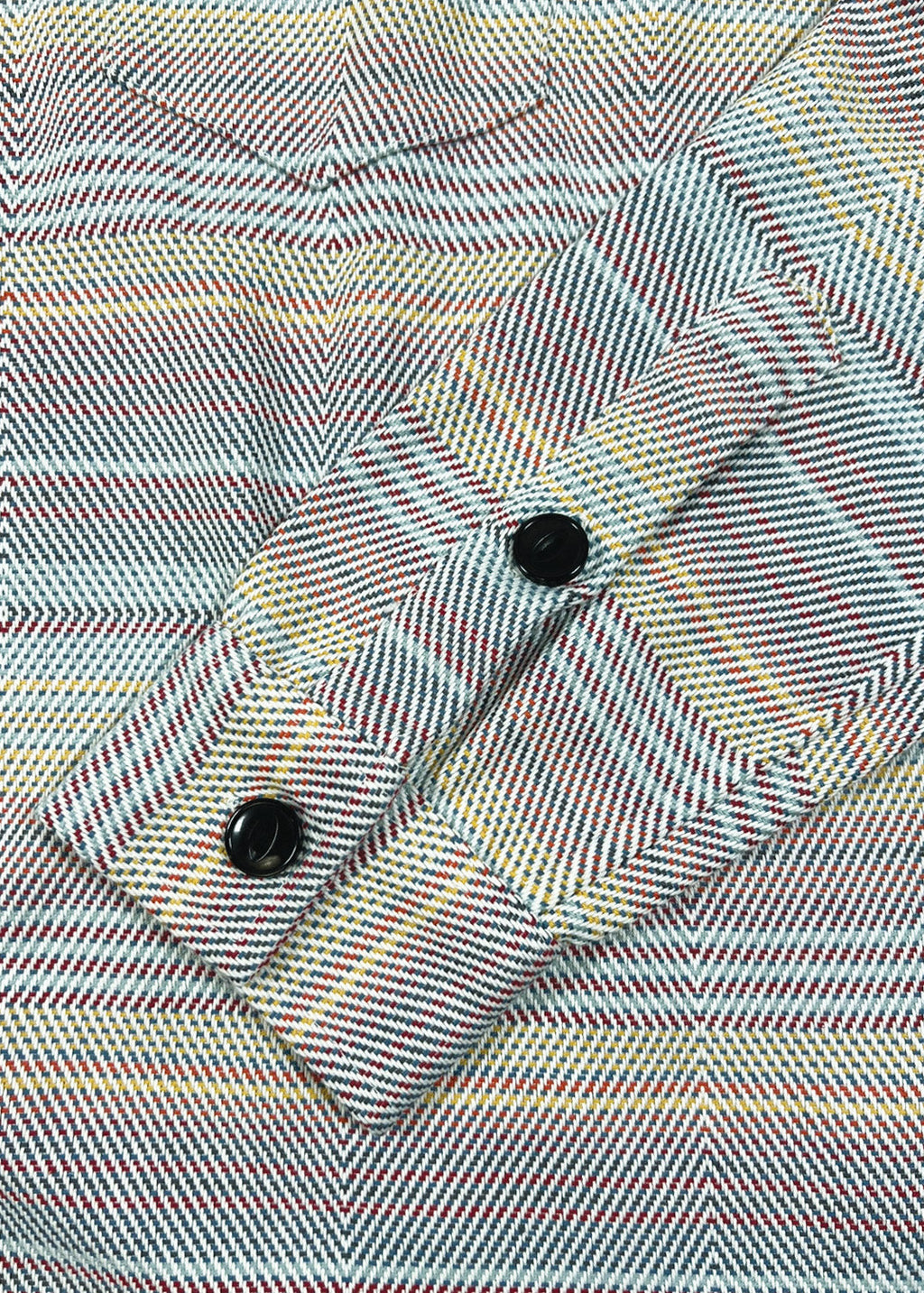 Close-up of a plaid fabric with two black buttons on a multicolored background