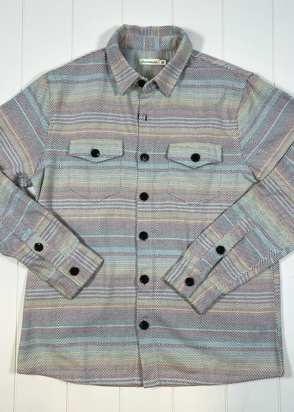 Striped shirt with button details on a white wooden surface