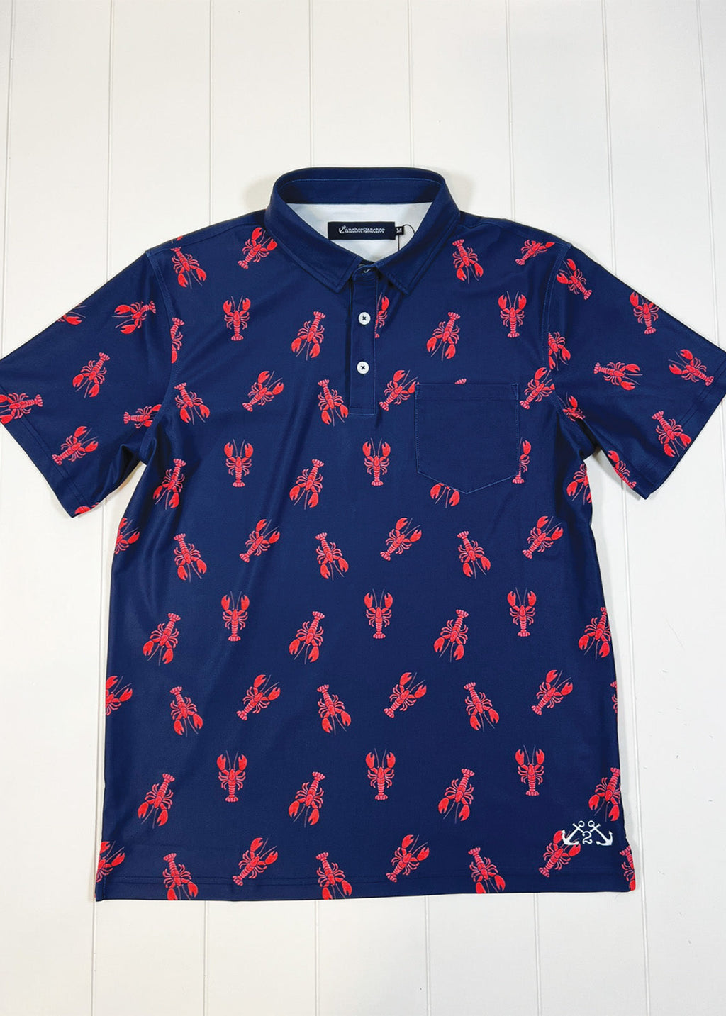 Navy blue polo shirt with red lobster pattern on a white background