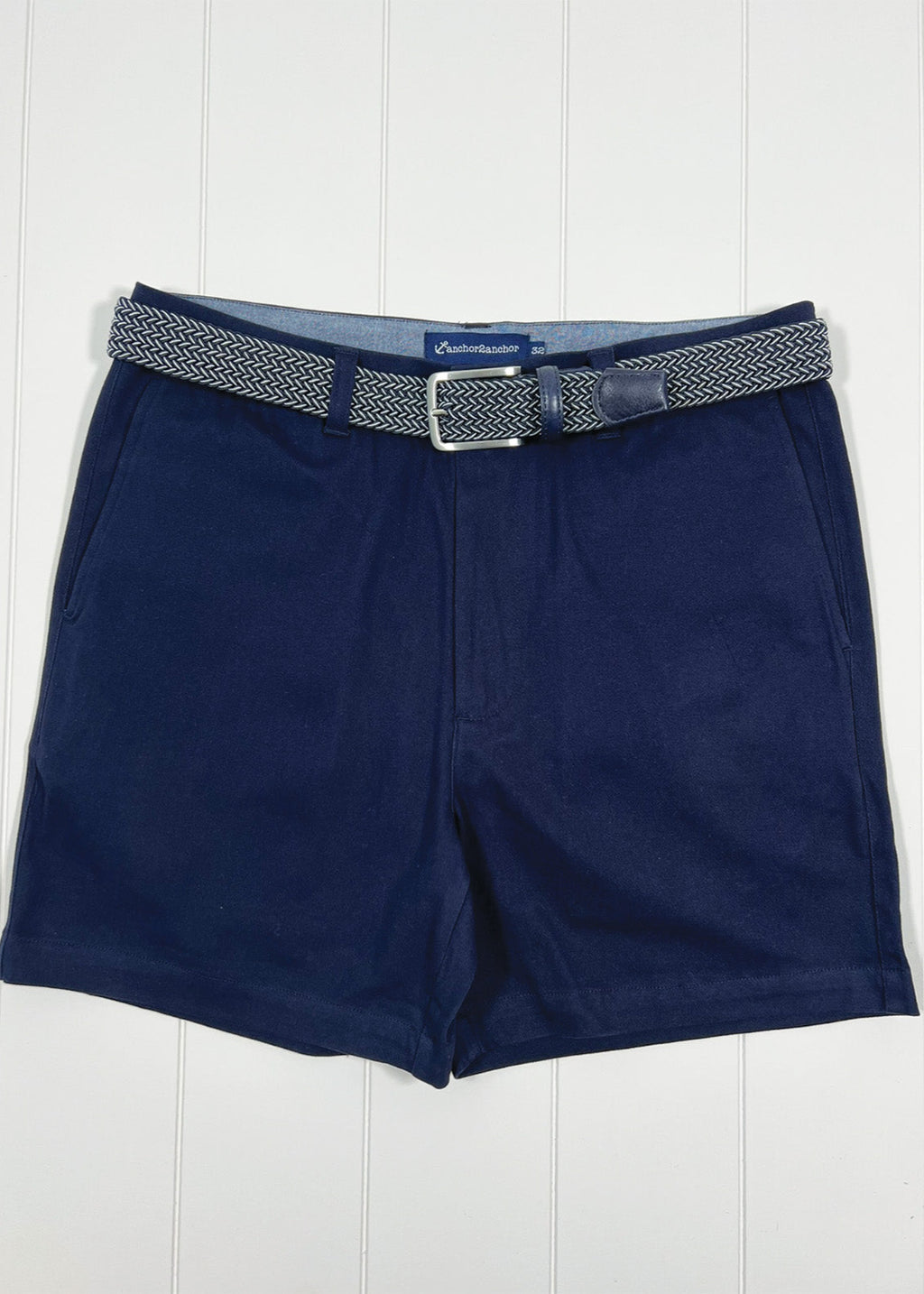 Navy shorts with a belt on a white wooden background