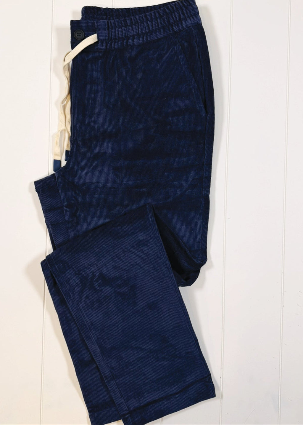 Folded blue pants on a white background