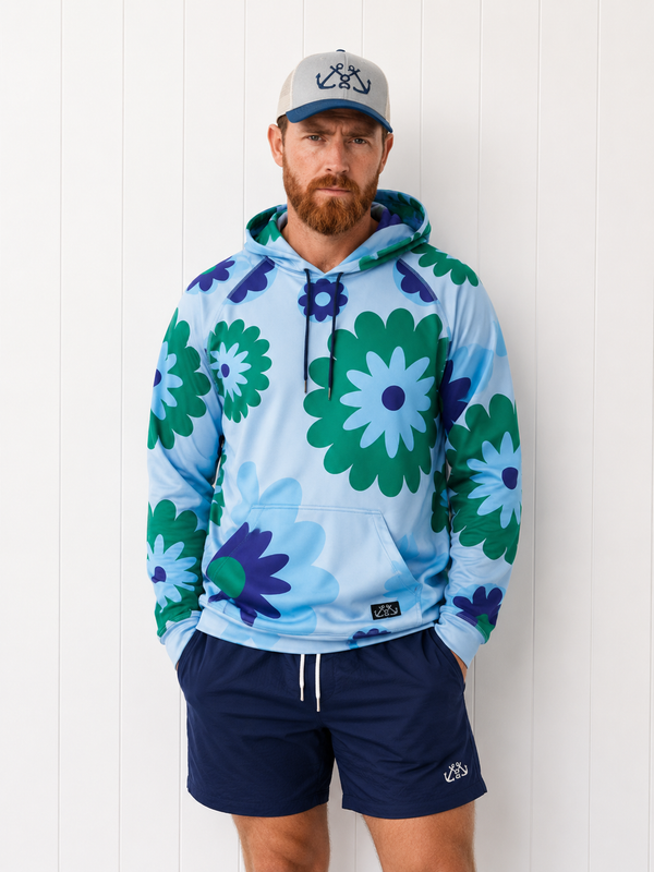 Man wearing a colorful floral hoodie and navy shorts against a white background