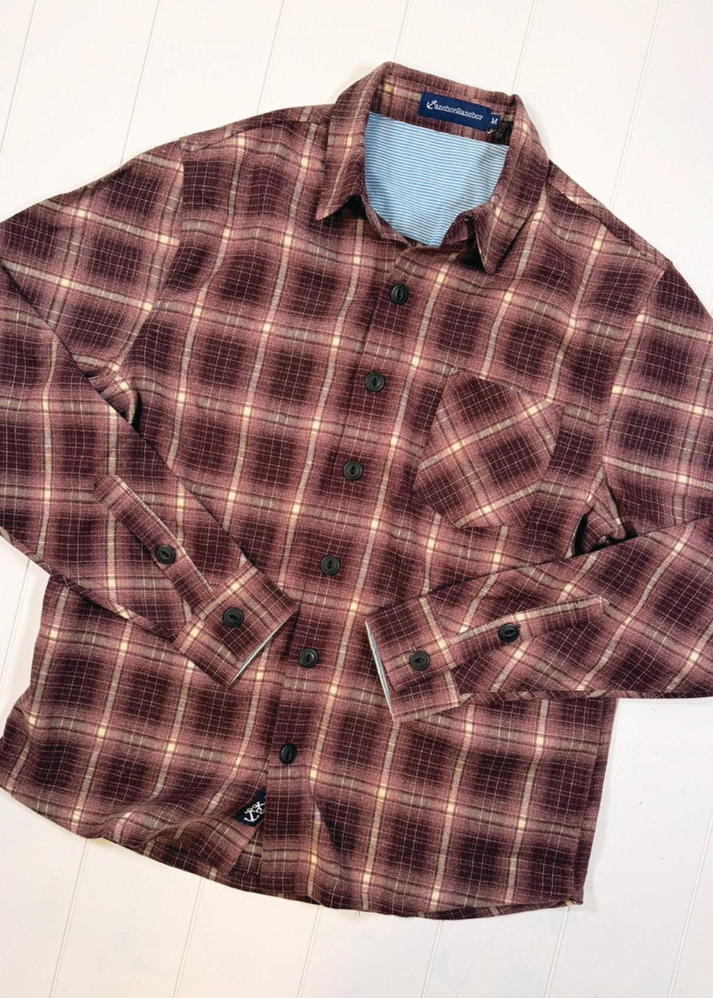 Plaid shirt with a visible brand label on a white background