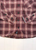 Close-up of a purple plaid shirt with buttons on a white background