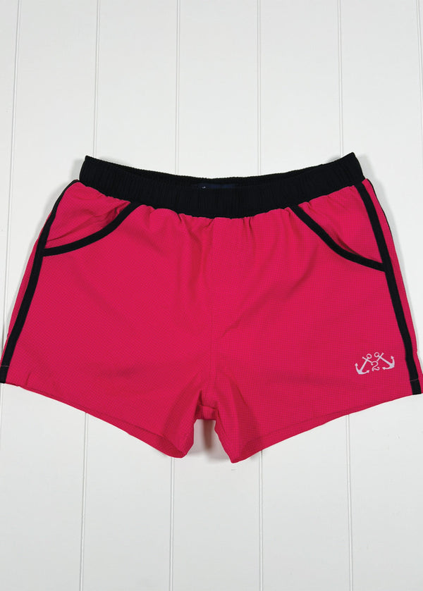 Red shorts with black trim on a white wooden background