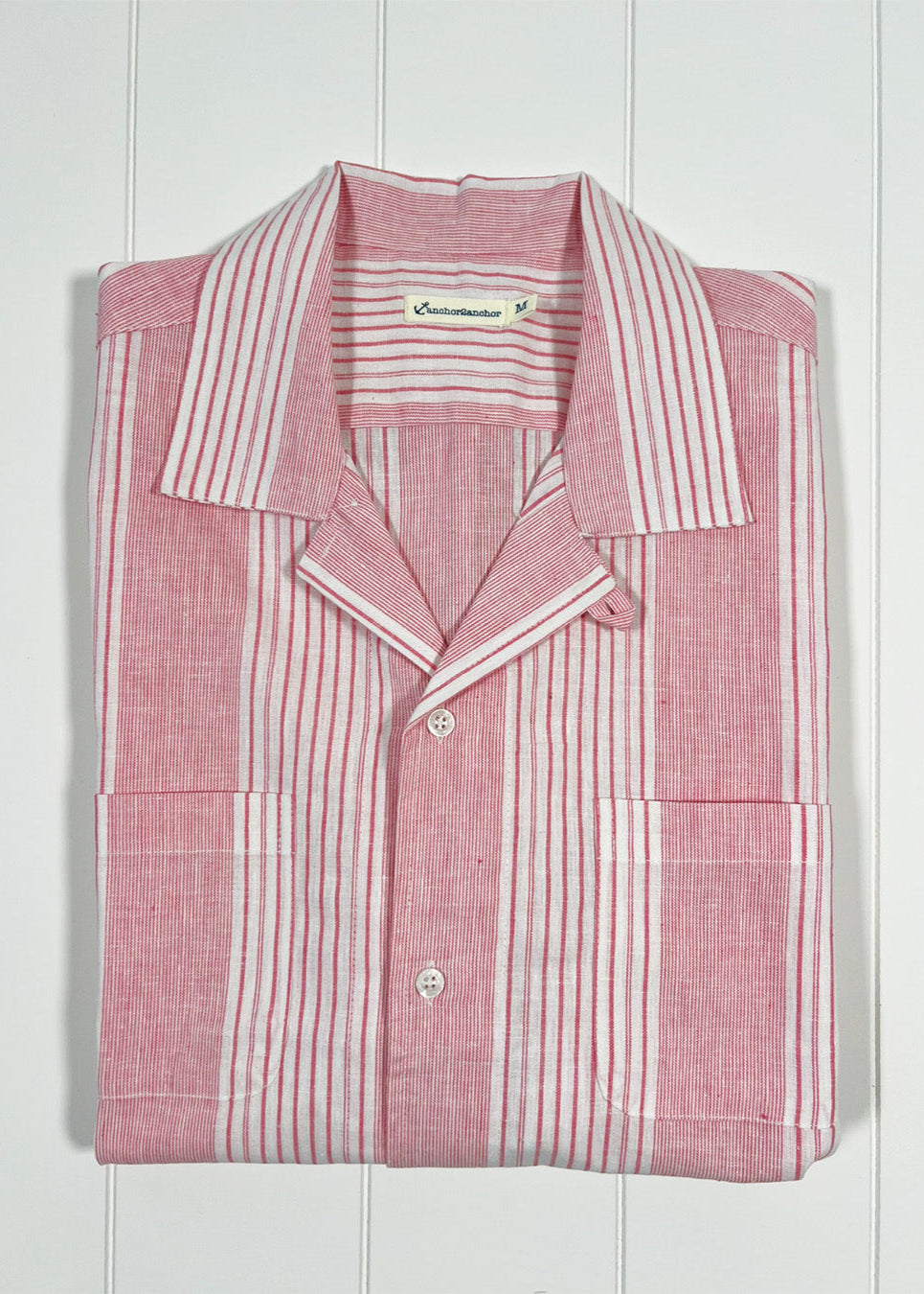 Pink and white striped shirt on a white wooden background