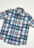 Plaid short-sleeve shirt with blue, red, and white pattern on a light wooden surface