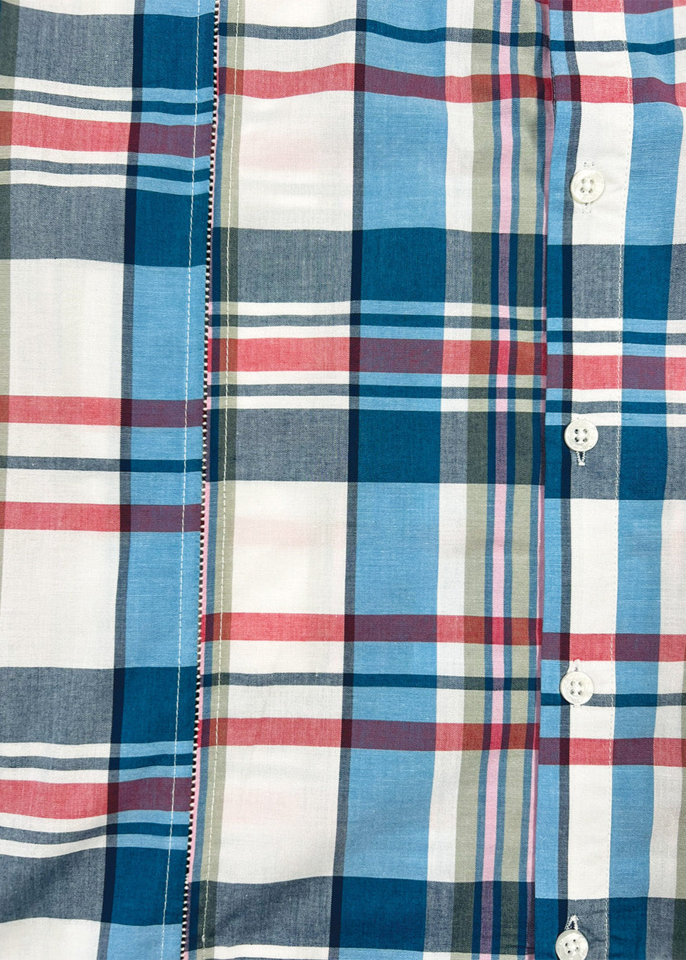 Close-up of a plaid shirt with blue, red, and white colors.