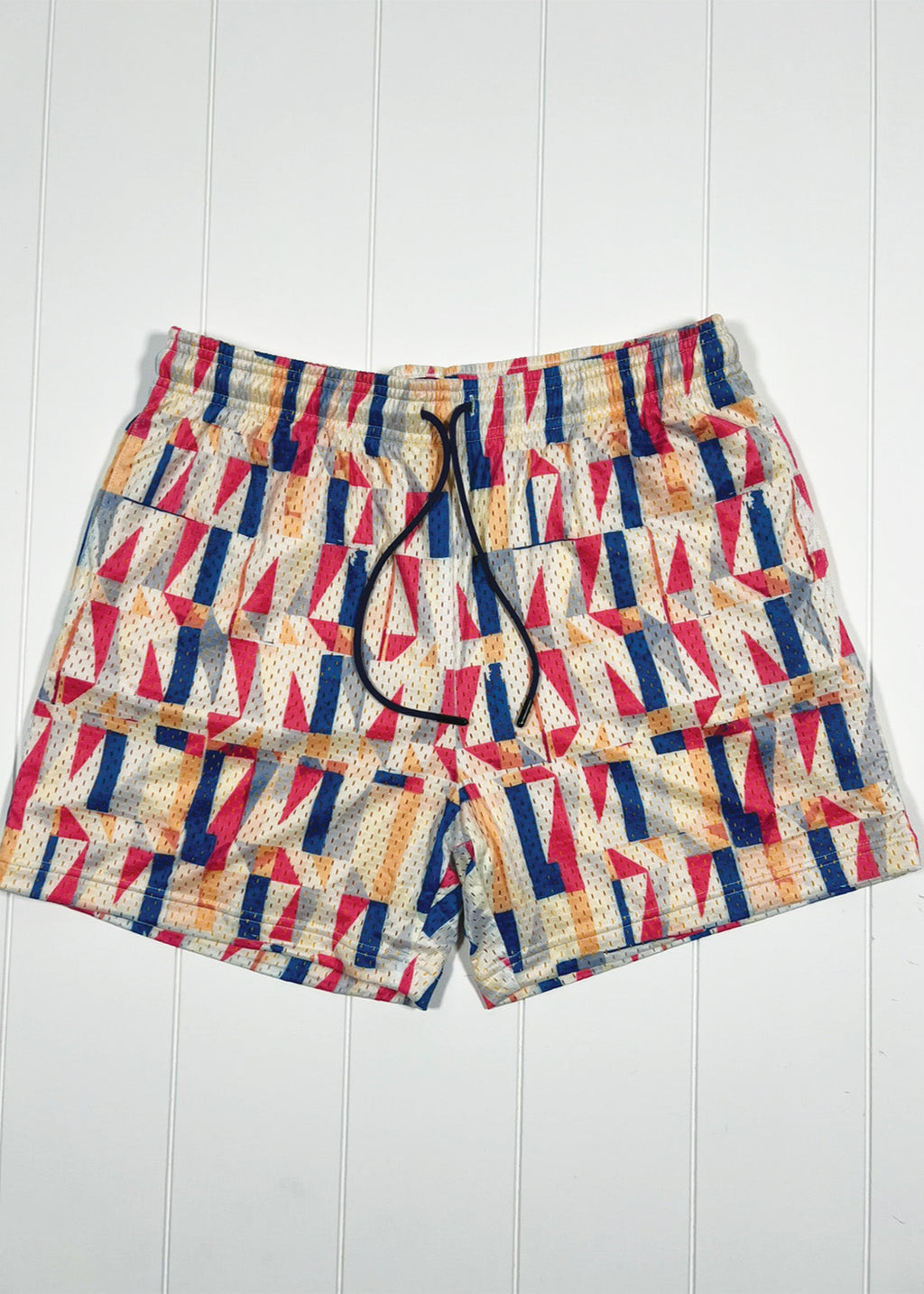 Colorful geometric patterned shorts on a white wooden background