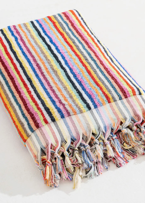 Multicolored striped towel with tassels on a white background