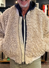 Man wearing a textured beige jacket in a clothing store
