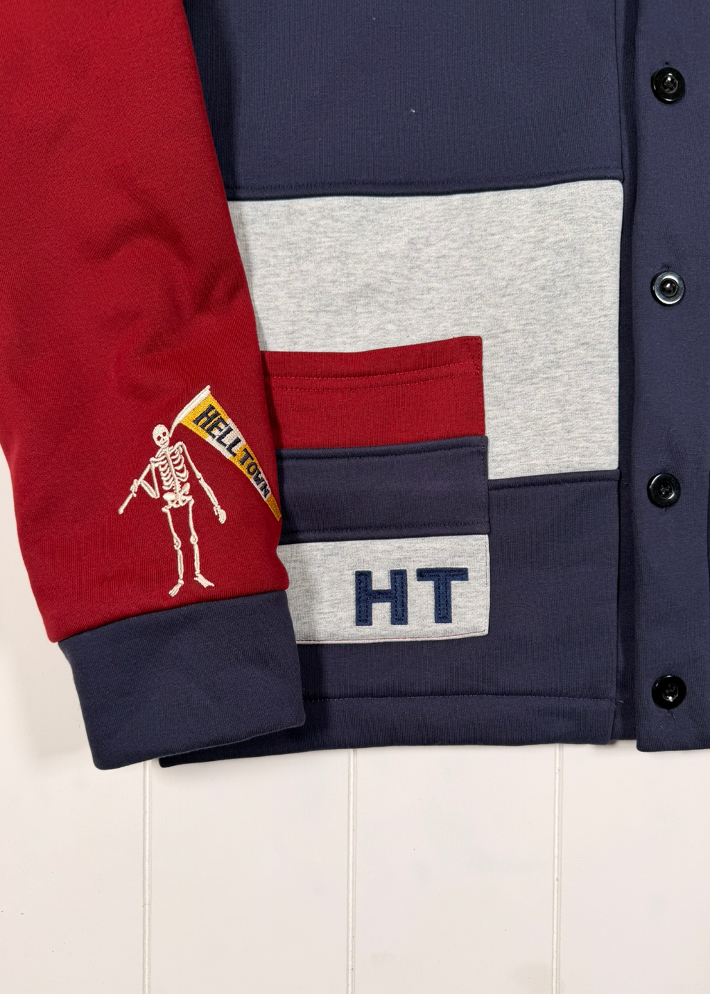Color-blocked jacket with red, navy, gray, and white sections on a white background