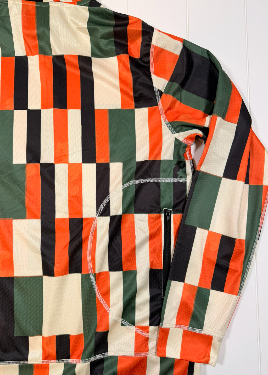 Checkered jacket with orange, green, and black pattern on a white background