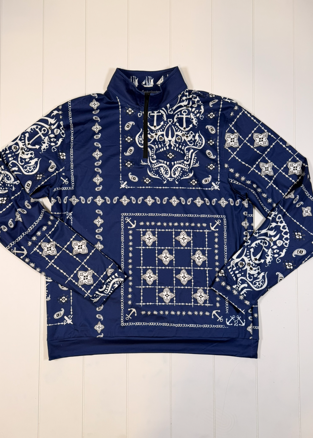 Navy blue sweatshirt with white bandana pattern on a white wooden background